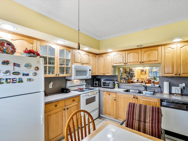 kitchen featuring white appliances, sink, a textured ceiling, hanging light fixtures, and light tile patterned floors