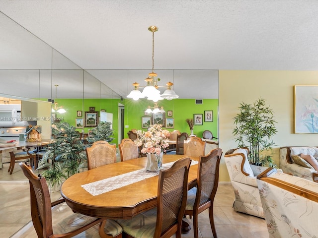 dining room with a notable chandelier, a textured ceiling, and light tile patterned floors