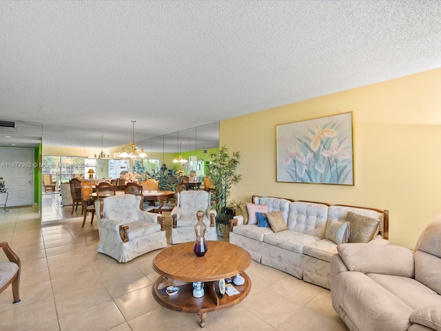 living room featuring a chandelier, a textured ceiling, and light tile patterned floors