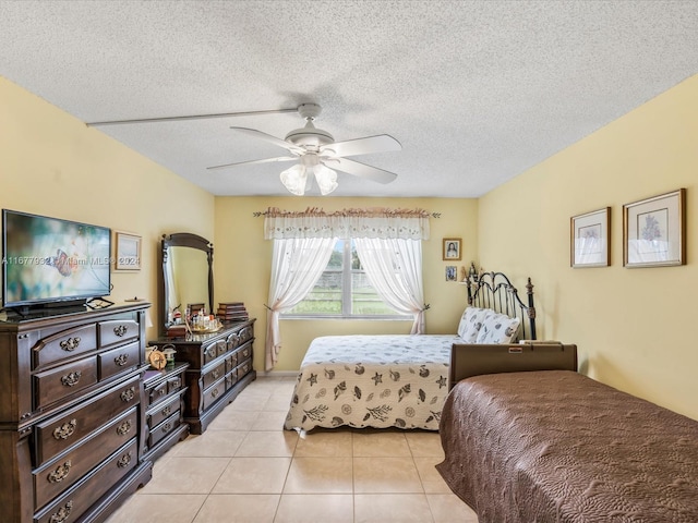 tiled bedroom with ceiling fan and a textured ceiling