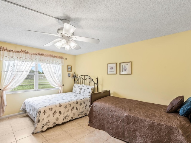 bedroom featuring ceiling fan, a textured ceiling, and light tile patterned floors