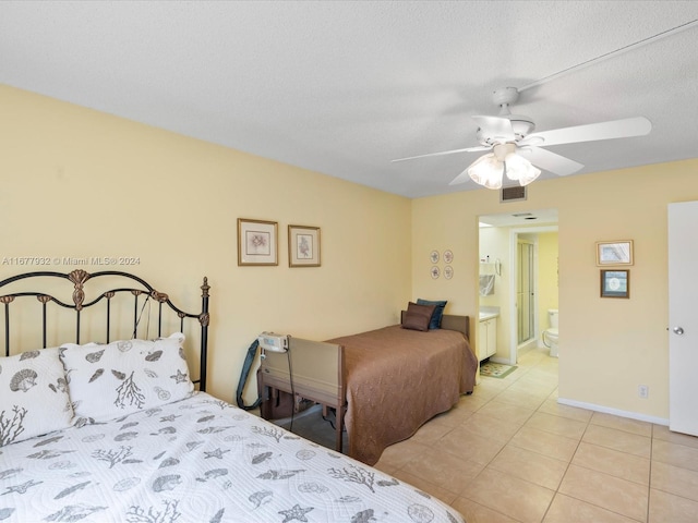 tiled bedroom featuring connected bathroom, ceiling fan, and a textured ceiling