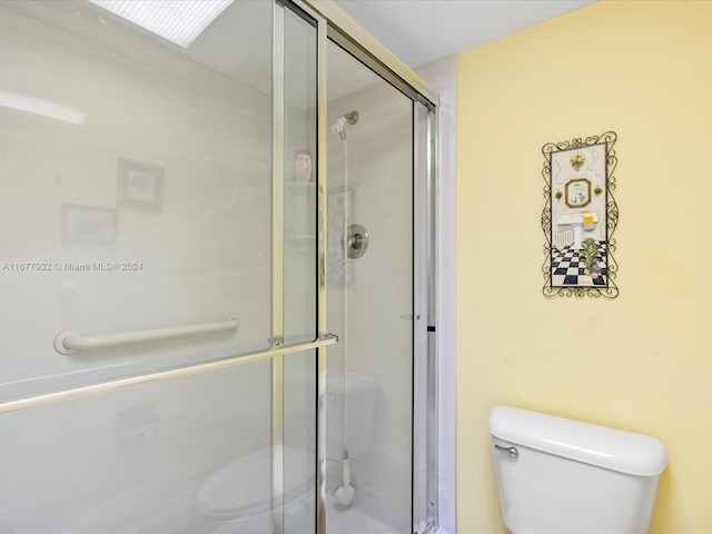 bathroom with toilet and an enclosed shower