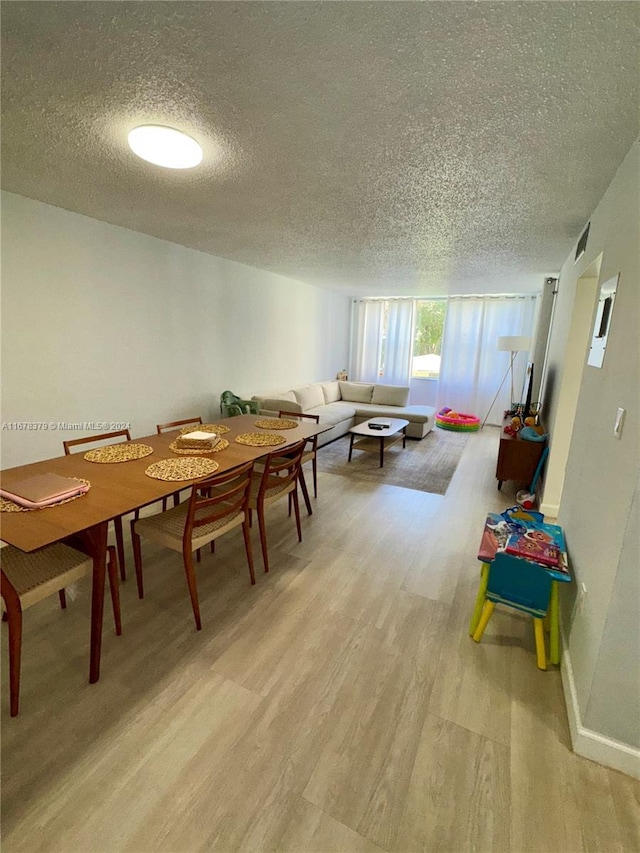 dining room with a textured ceiling and light hardwood / wood-style floors