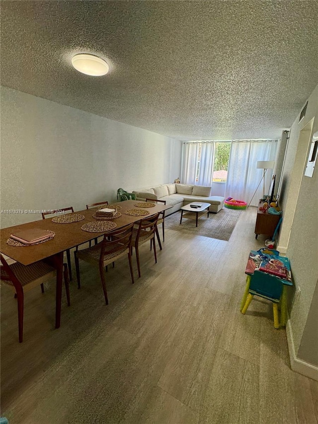 dining area featuring hardwood / wood-style flooring and a textured ceiling