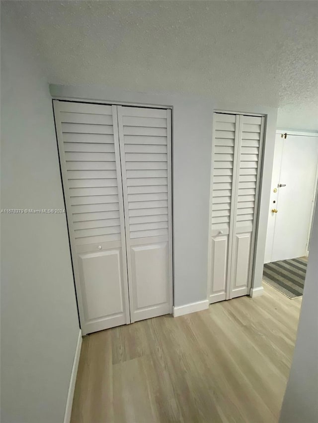 unfurnished bedroom with a textured ceiling and light hardwood / wood-style floors