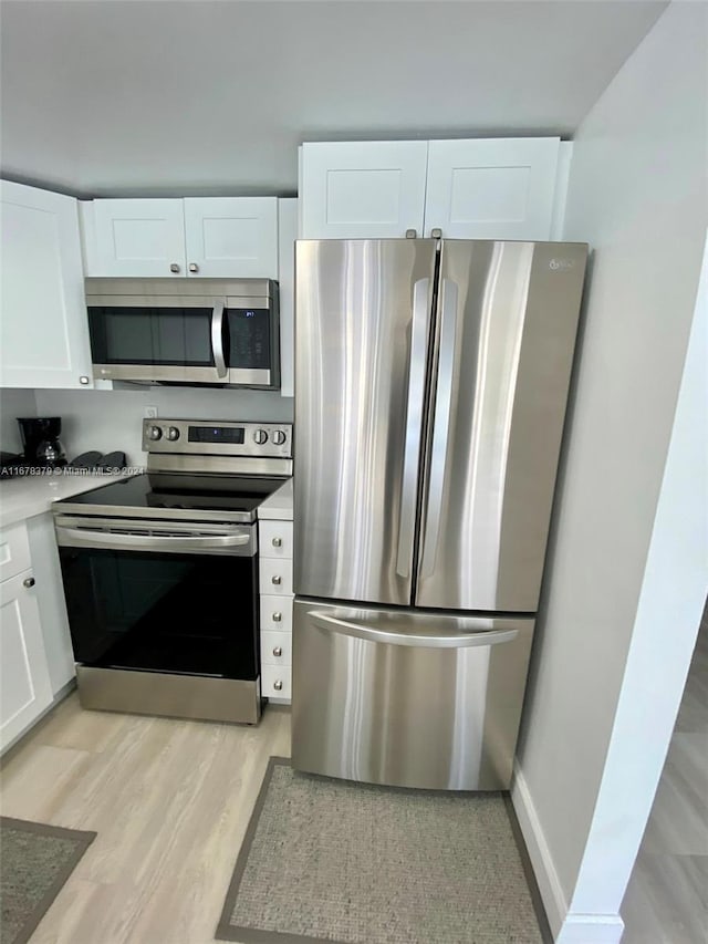 kitchen featuring white cabinets, stainless steel appliances, and light hardwood / wood-style floors