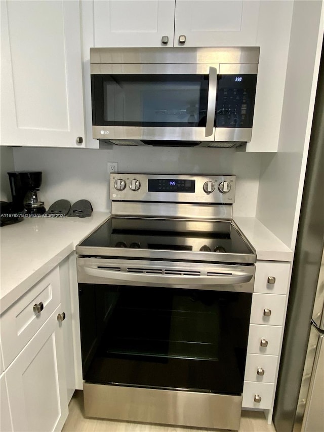 kitchen with white cabinets and appliances with stainless steel finishes