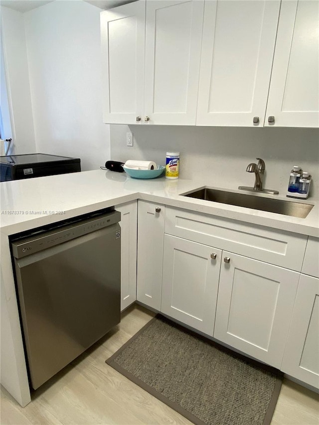 kitchen featuring dishwasher, light hardwood / wood-style floors, white cabinets, and sink