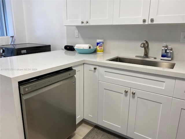 kitchen featuring dishwasher, white cabinetry, and sink