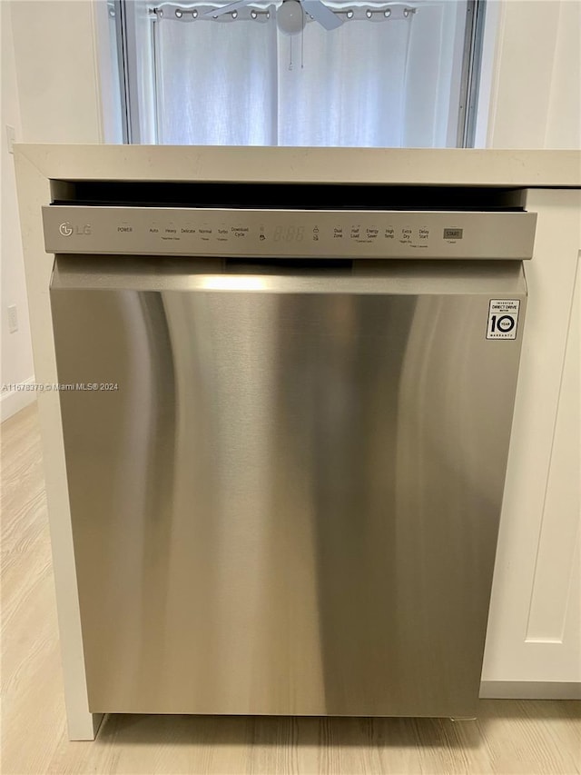 room details with dishwasher, light hardwood / wood-style flooring, and white cabinetry