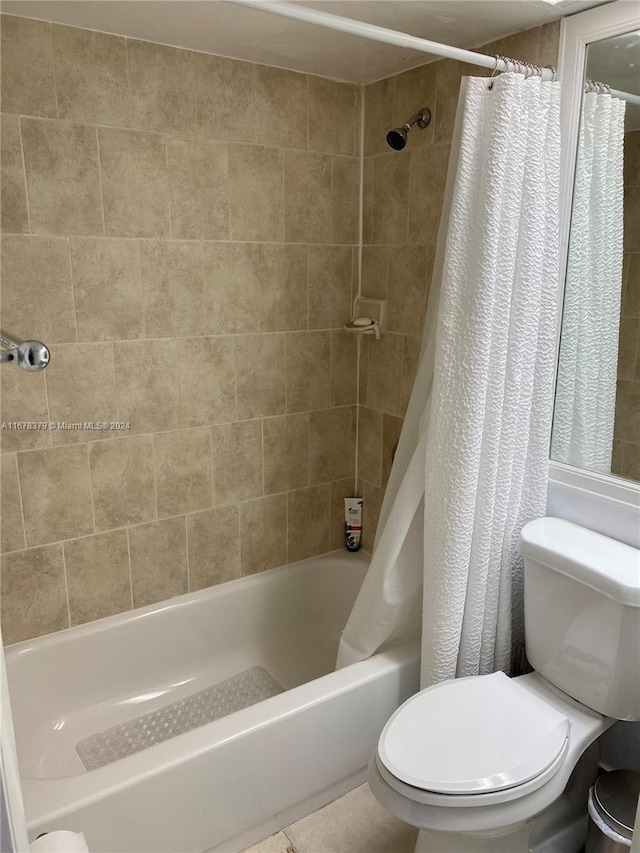 bathroom featuring shower / bath combo with shower curtain and toilet