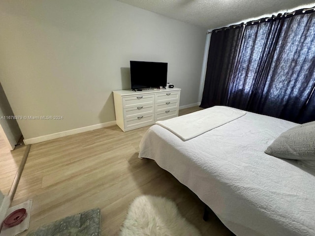 bedroom featuring a textured ceiling and light wood-type flooring