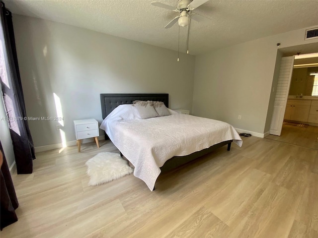 bedroom featuring a textured ceiling, light hardwood / wood-style floors, and ceiling fan