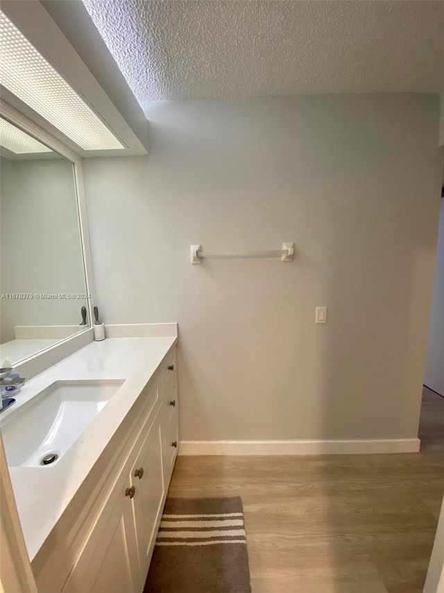 bathroom featuring hardwood / wood-style floors, vanity, and a textured ceiling