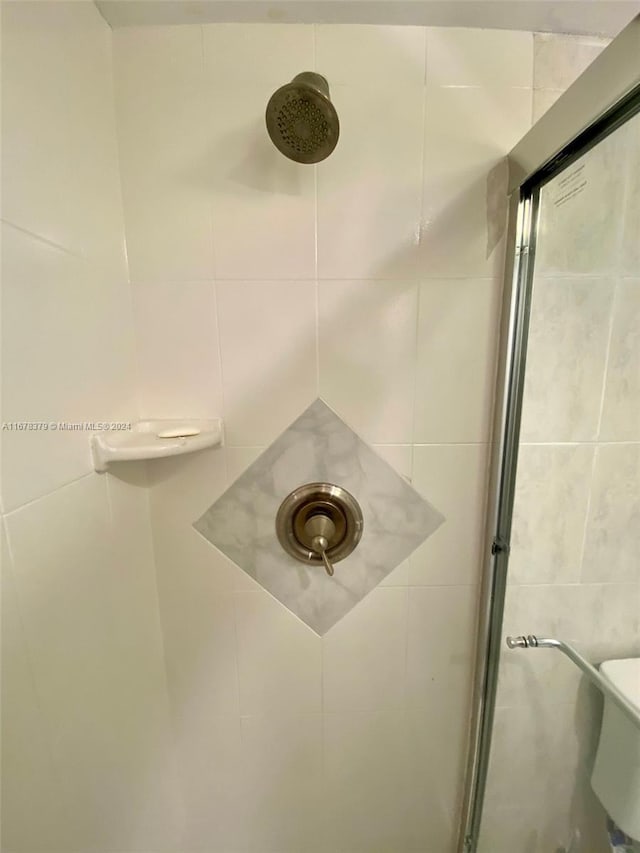 interior details featuring a tile shower