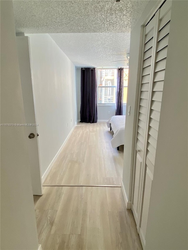 hallway featuring a textured ceiling and light wood-type flooring