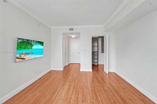 unfurnished living room with light hardwood / wood-style floors and crown molding