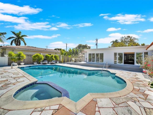 view of pool with an in ground hot tub and a patio