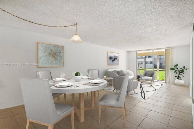 tiled dining area featuring a textured ceiling and floor to ceiling windows