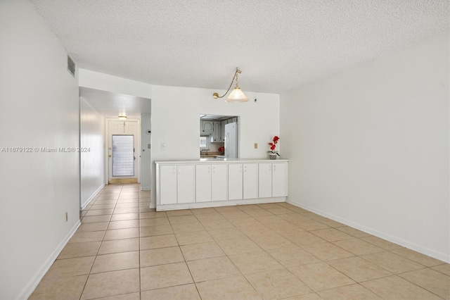 tiled empty room with a textured ceiling