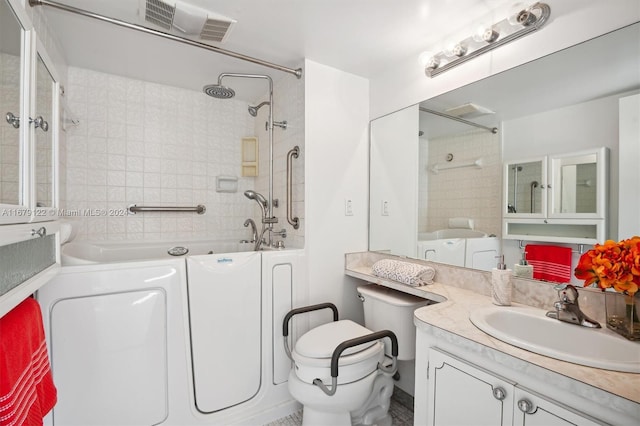 full bathroom featuring tiled shower / bath, vanity, toilet, and washer / clothes dryer