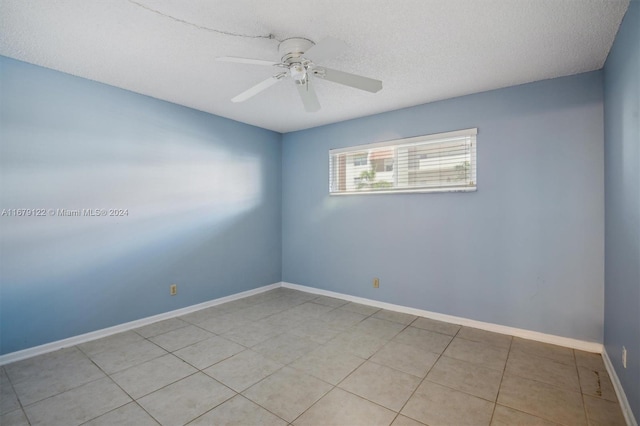 tiled spare room with a textured ceiling and ceiling fan