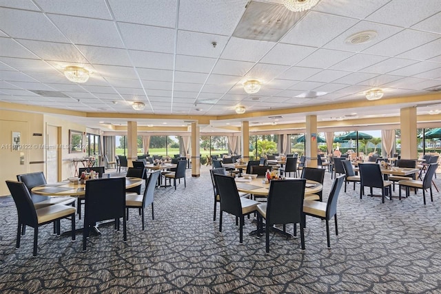 dining area featuring a paneled ceiling and carpet floors