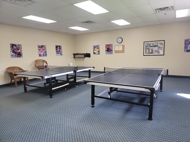 game room with a paneled ceiling and carpet flooring