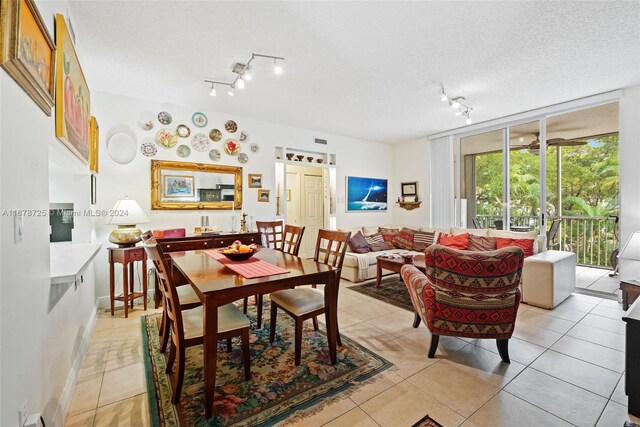 tiled dining area featuring a textured ceiling and rail lighting