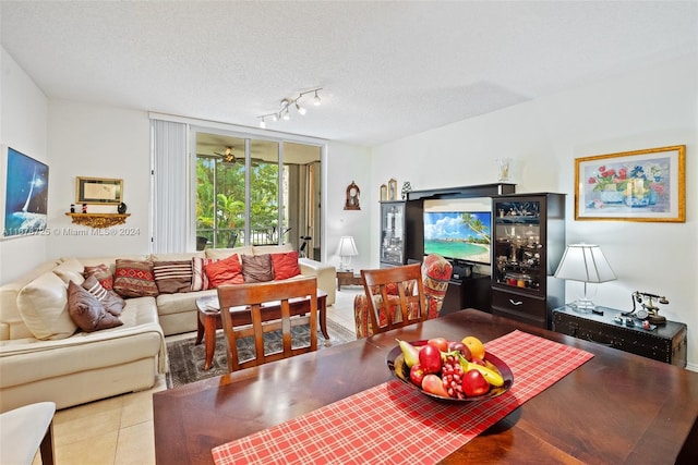 living room featuring a textured ceiling, tile patterned flooring, track lighting, and ceiling fan