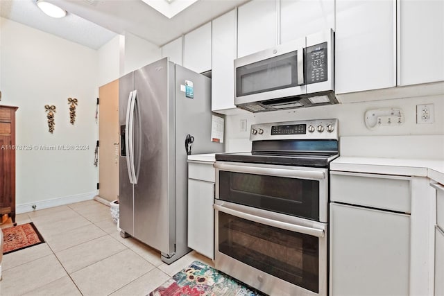 kitchen with white cabinetry, appliances with stainless steel finishes, and light tile patterned flooring