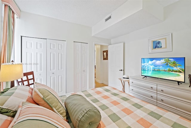 bedroom featuring a textured ceiling and two closets