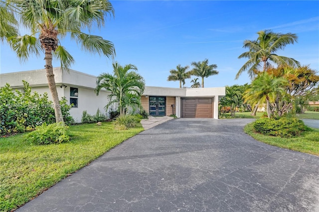 view of front of house with a front yard and a garage