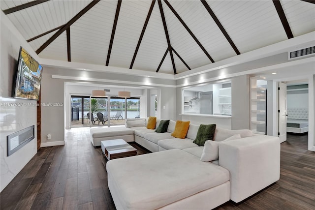 living room with high vaulted ceiling, wood finished floors, a glass covered fireplace, baseboards, and visible vents