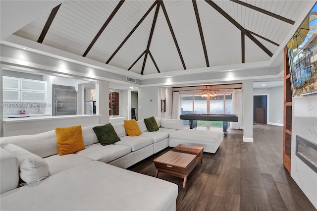living room with dark wood finished floors, visible vents, baseboards, high vaulted ceiling, and a notable chandelier