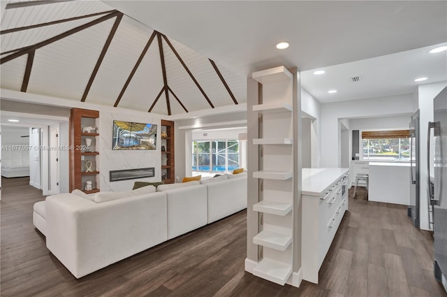 living room featuring a fireplace, vaulted ceiling with beams, and dark hardwood / wood-style floors