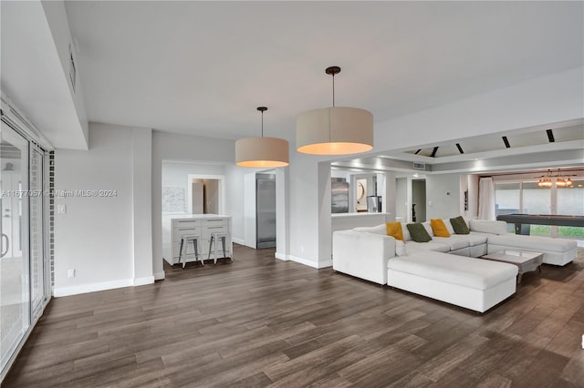 unfurnished living room with dark wood-type flooring and a chandelier