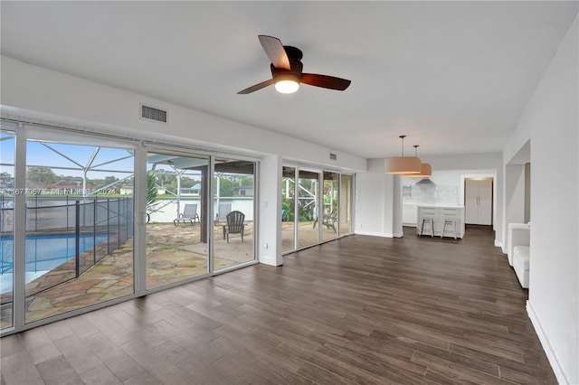 unfurnished living room featuring ceiling fan and dark hardwood / wood-style floors