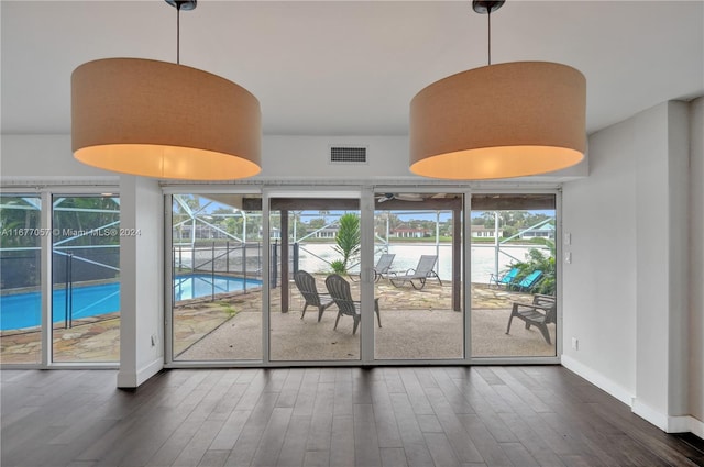 unfurnished dining area with a healthy amount of sunlight and dark hardwood / wood-style flooring