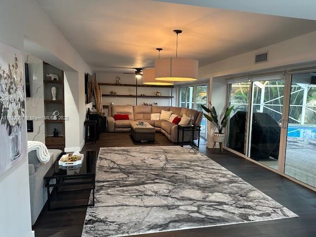 living area with wood finished floors and visible vents