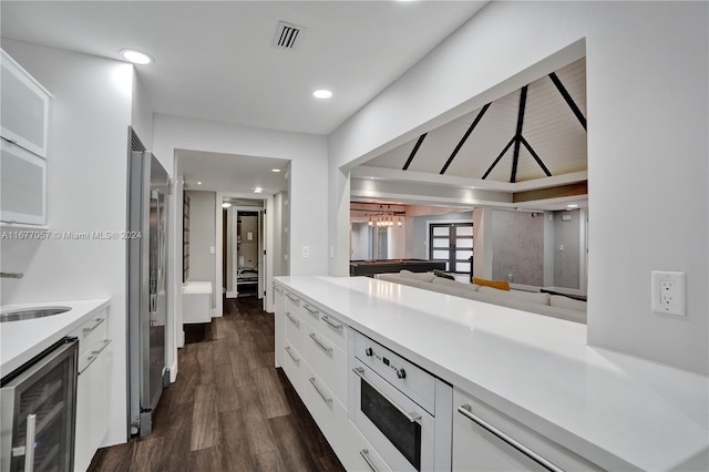 kitchen with white cabinetry, stainless steel appliances, beverage cooler, dark wood-type flooring, and billiards