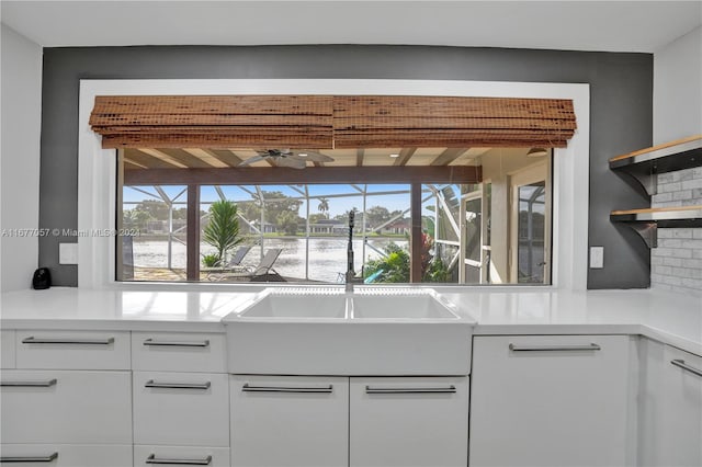 kitchen with sink, white cabinets, a healthy amount of sunlight, and tasteful backsplash