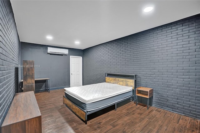 bedroom featuring brick wall, a wall mounted AC, and dark hardwood / wood-style flooring