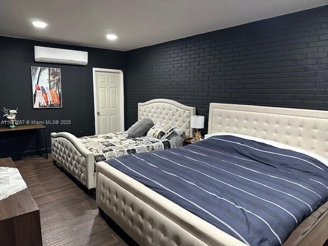 bedroom with brick wall, wood finished floors, recessed lighting, and a wall unit AC
