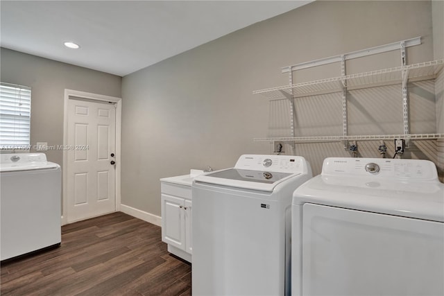 laundry room featuring cabinets, washer and clothes dryer, and dark hardwood / wood-style flooring