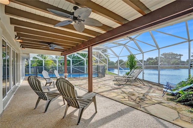 view of patio featuring a water view, glass enclosure, and ceiling fan