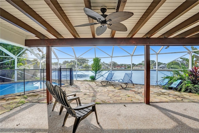 view of patio featuring a lanai, a water view, and ceiling fan