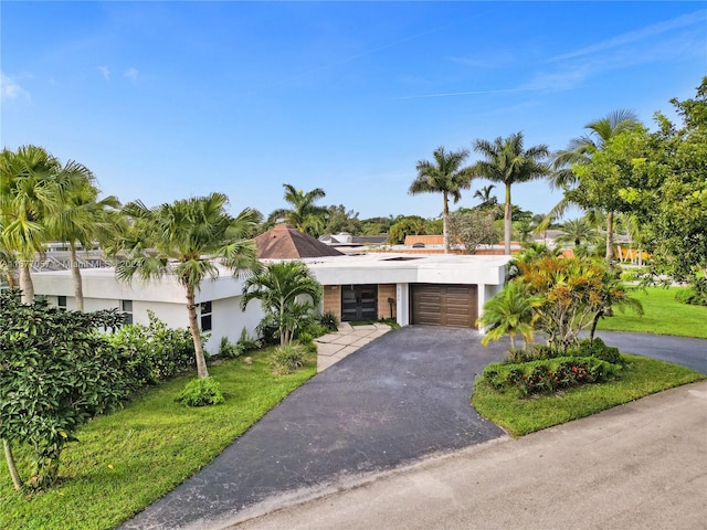 view of front of house with a front yard and a garage