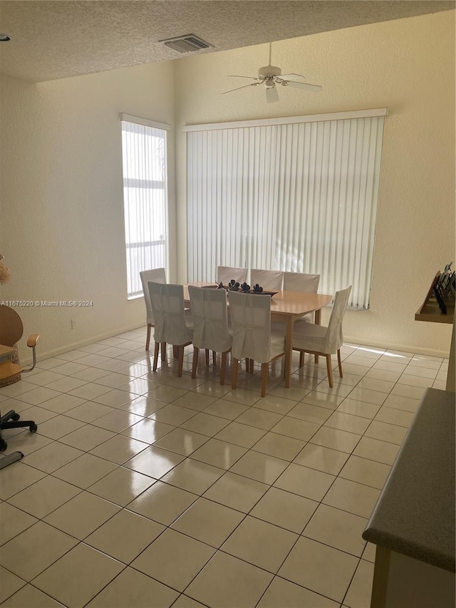 tiled dining space featuring ceiling fan and a textured ceiling